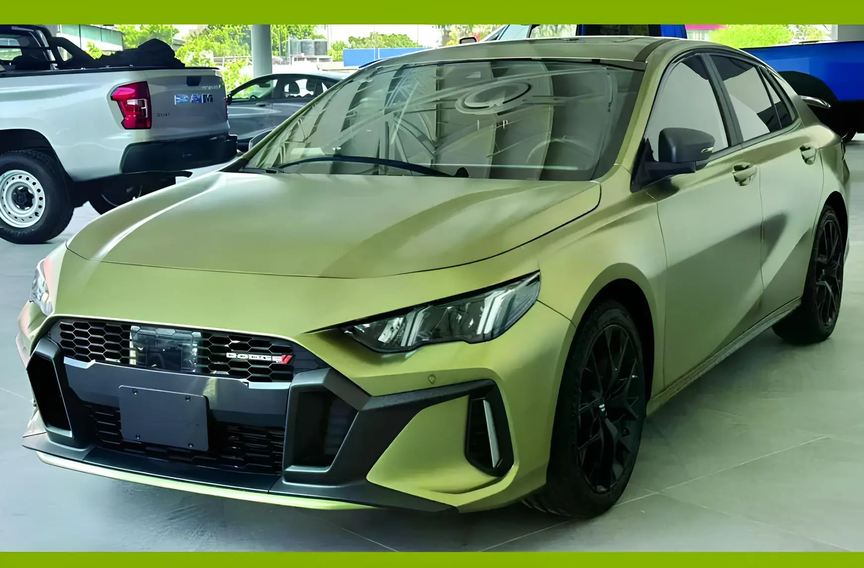 Оливково-зелений седан Dodge у шоурумі, агресивний передній бампер, чорні легкосплавні диски