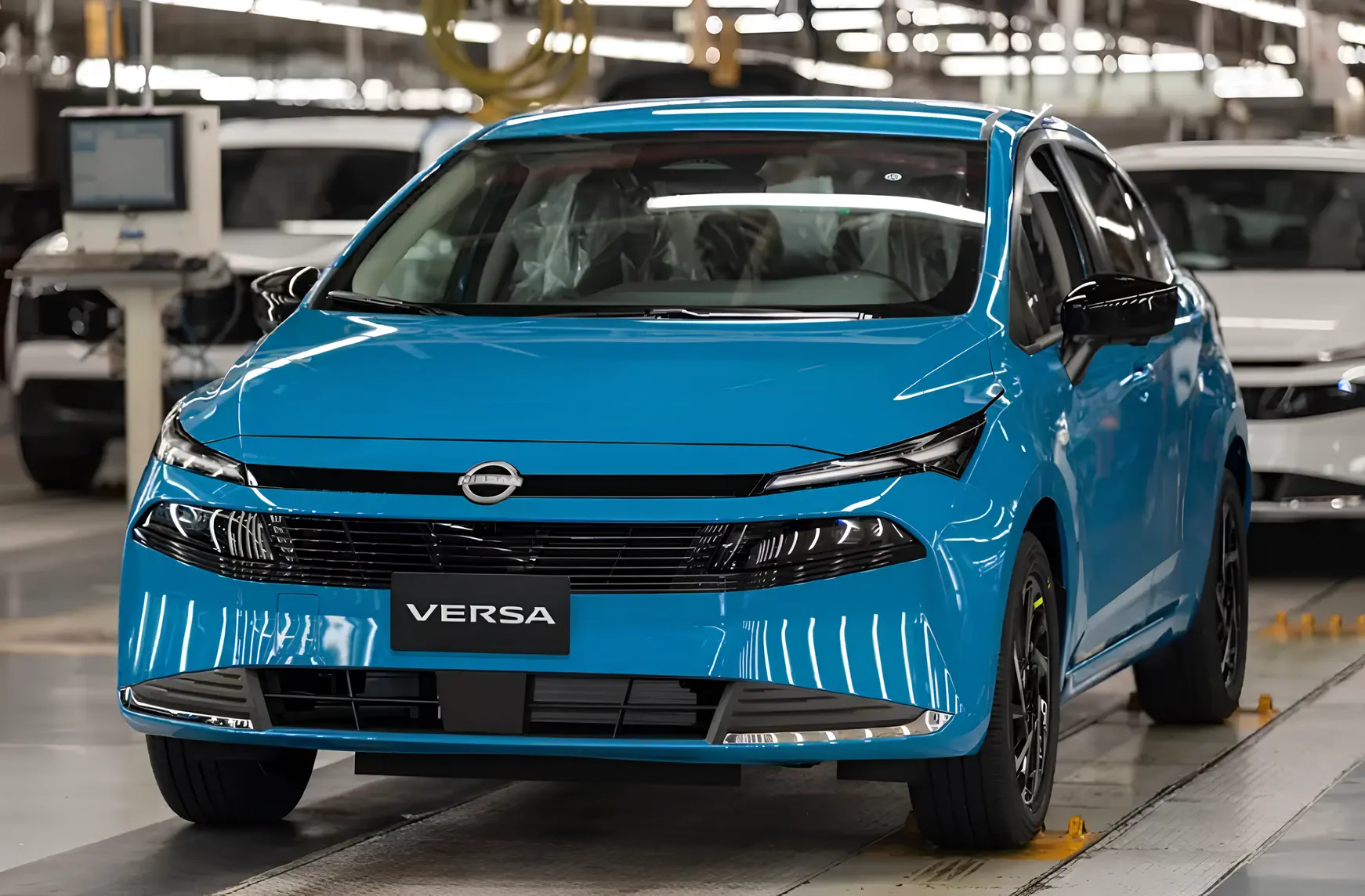 Синій Nissan Versa на конвеєрі в цеху складання, вигляд спереду