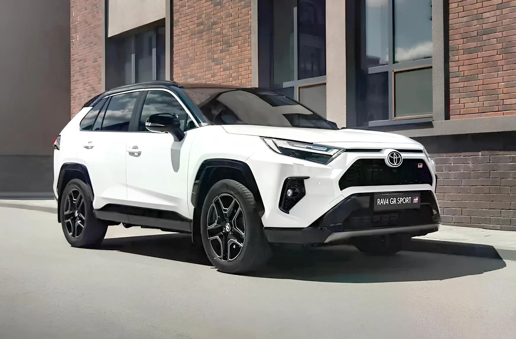 Toyota RAV4 у білому кольорі: кросовер у місті, передній ракурс біля будівлі
