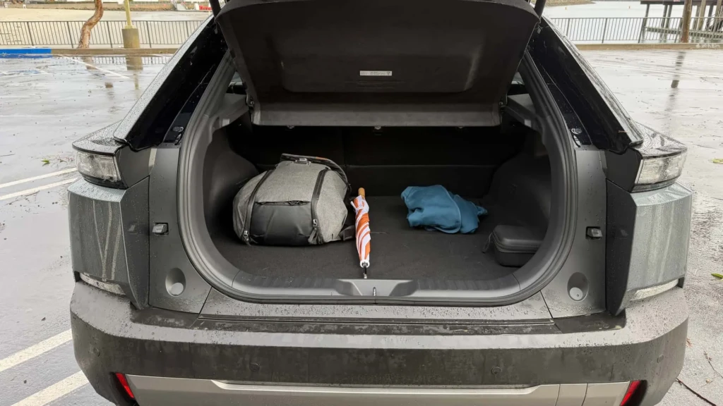 Багажник кросовера Subaru з відкритою кришкою: валіза/сумка, парасоля та куртка, вигляд ззаду