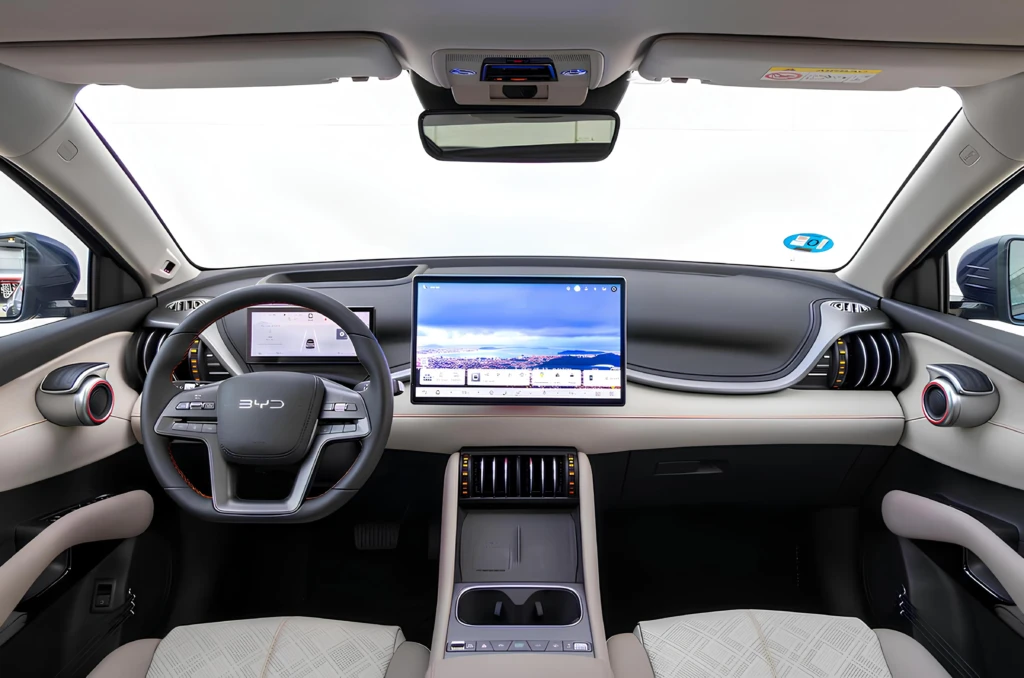Салон BYD Atto 3 с мультимедийным дисплеем, цифровой панелью приборов и рулем, вид с передних сидений