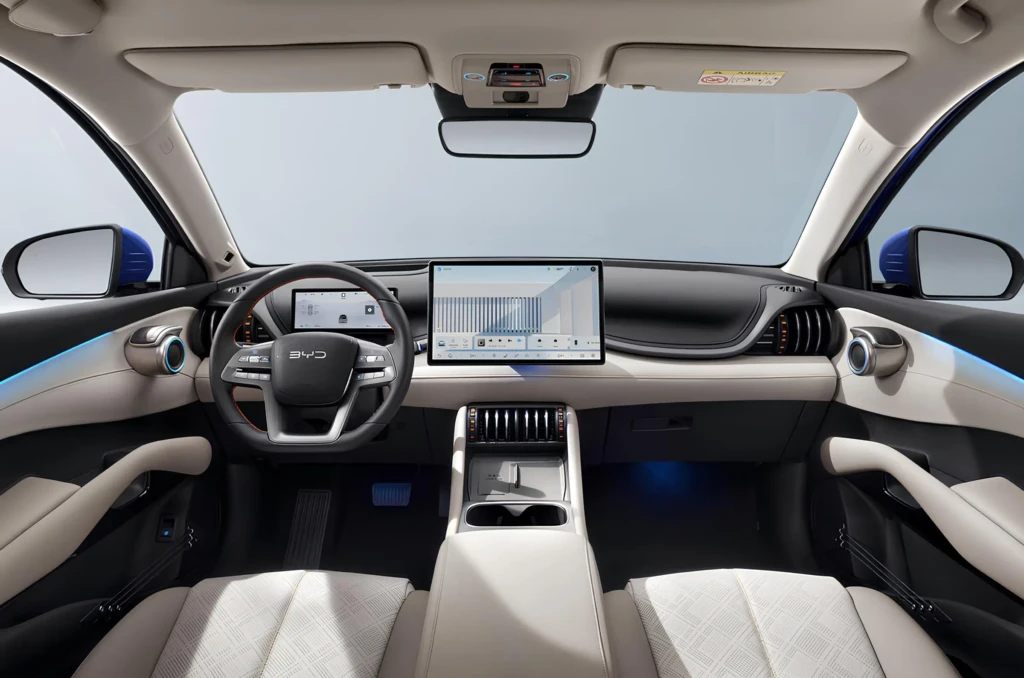 Інтер’єр BYD Atto 3 Evo: вид спереду на панель приладів із великим центральним екраном, кермо та центральну консоль у світлому салоні BYD