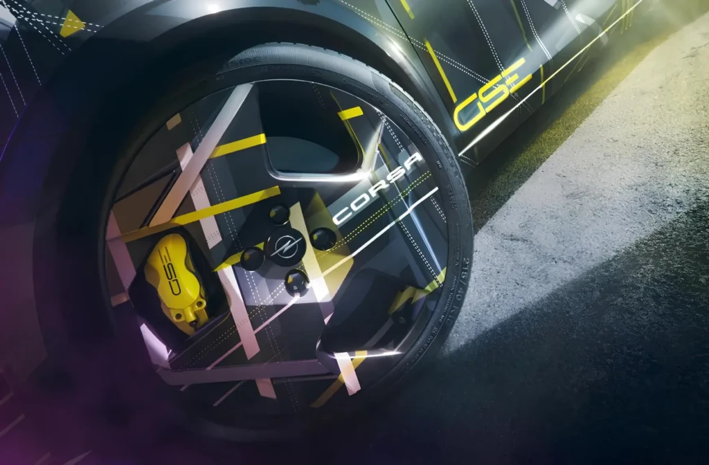 Крупний план колеса Opel Corsa з диском у стилі GS, жовтим гальмівним супортом і графікою кузова