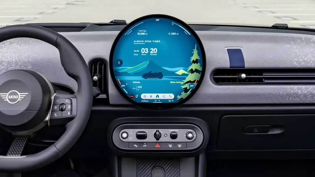 Інтер’єр MINI з великим круглим центральним дисплеєм на панелі приладів і кермом з логотипом MINI.