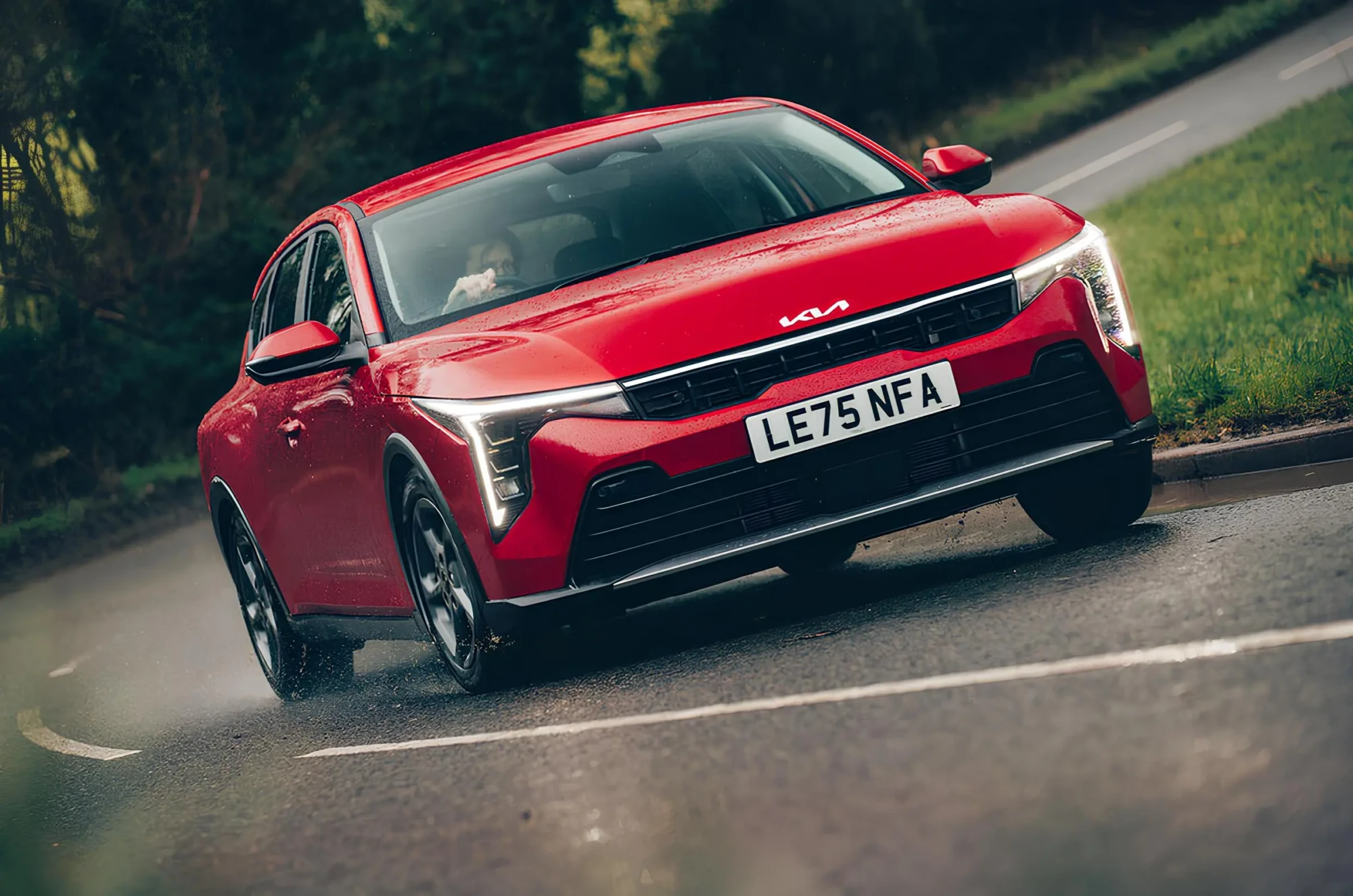 Червоний електрокросовер Kia на мокрій дорозі: динаміка та керованість у дощ