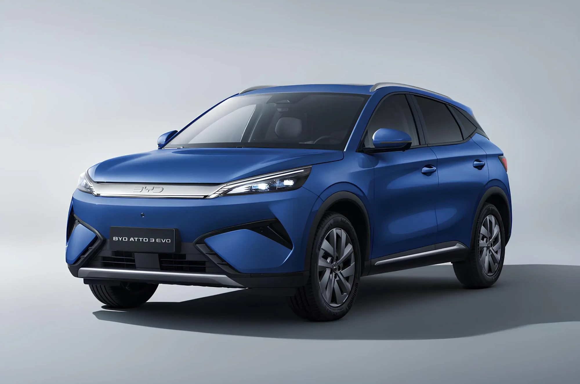 Синій електричний кросовер BYD Atto 3 Evo, вигляд спереду під кутом на світлому студійному фоні BYD