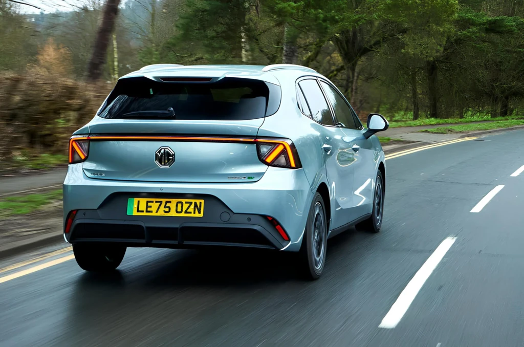 Електромобіль MG4 ззаду: світлий хетчбек їде дорогою, видно задні ліхтарі та номерний знак