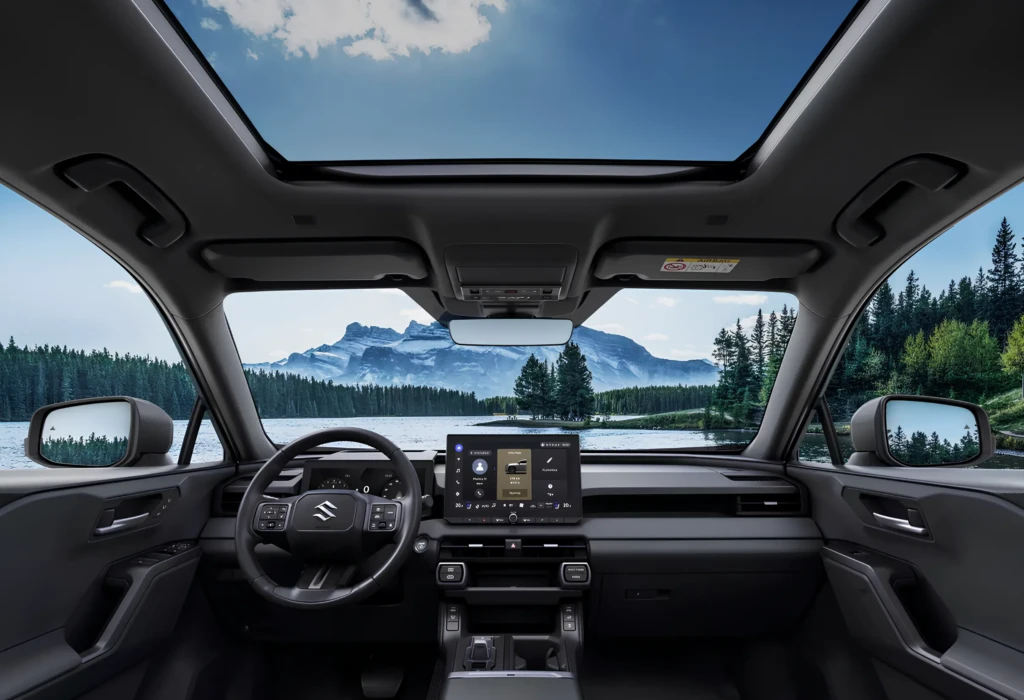Интерьер Suzuki с большим панорамным люком и центральным сенсорным экраном, вид на озеро и горы