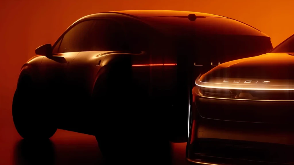 Тизер электрического кроссовера в темной студии: силуэт авто с LED-полосой фар на коричневом фоне