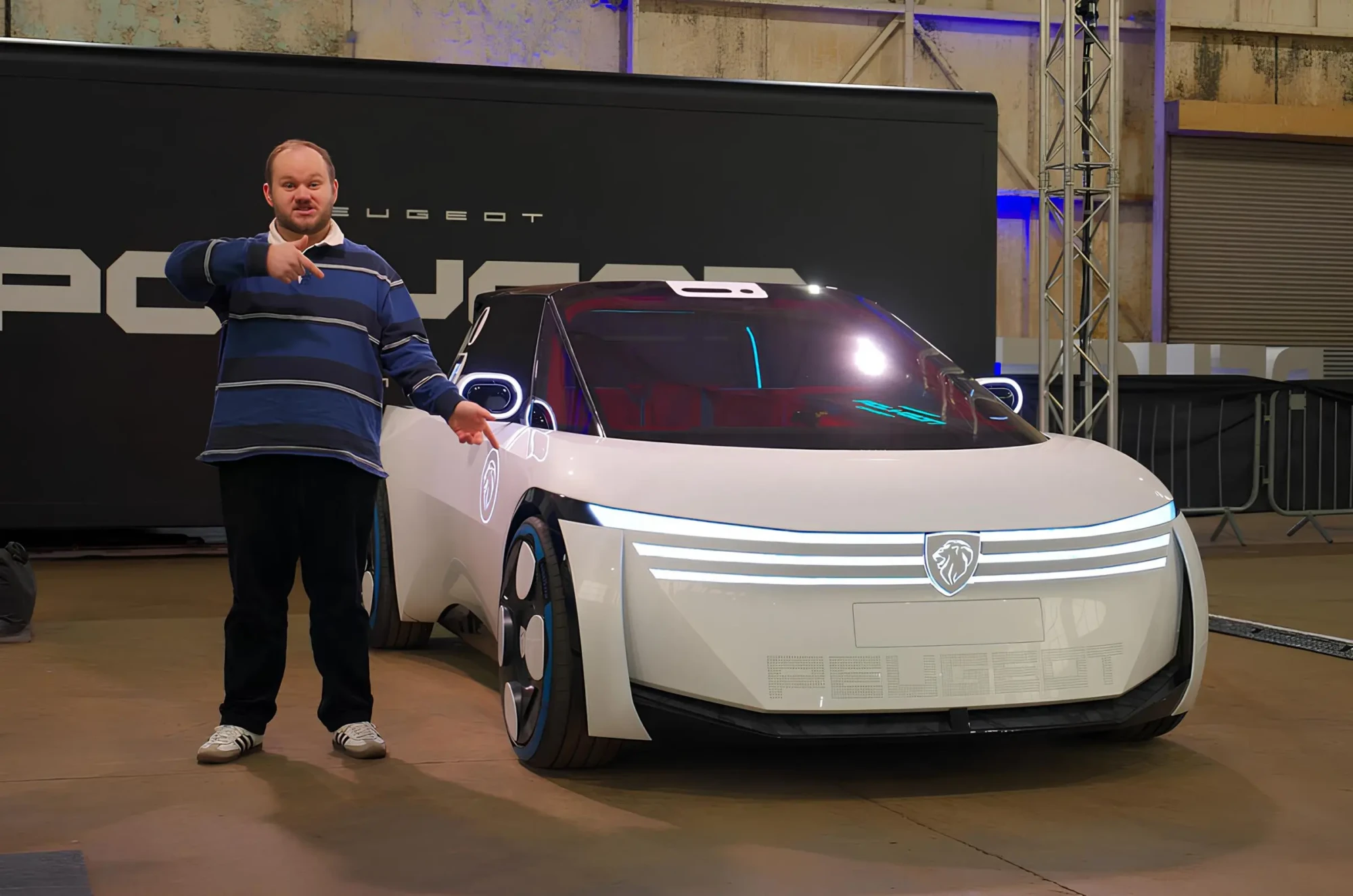 Концепт-кар Peugeot Polygon на презентації в павільйоні, поруч чоловік показує на автомобіль