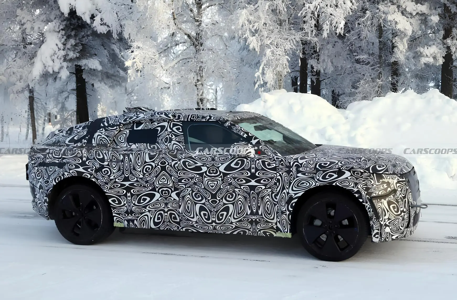 Замаскований прототип кросовера на зимових тестах у сніжному лісі, авто повністю в камуфляжній плівці.