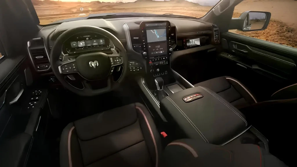 Салон пикапа RAM: руль с логотипом, цифровая приборная панель и большой вертикальный мультимедийный экран на фоне пустынного пейзажа за окном.