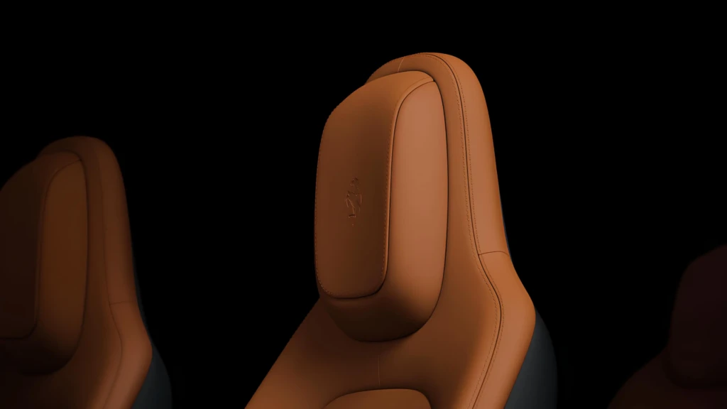 Коричневе шкіряне сидіння з підголівником і тисненим логотипом Ferrari на темному фоні
