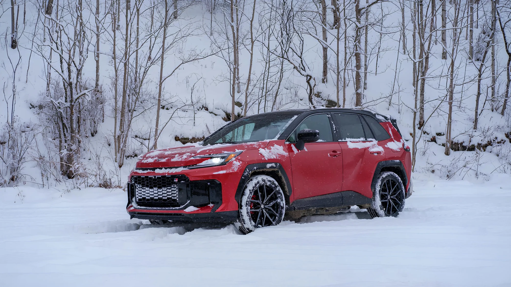 Червоний Toyota RAV4 у зимових умовах: кросовер їде по снігу на тлі лісу