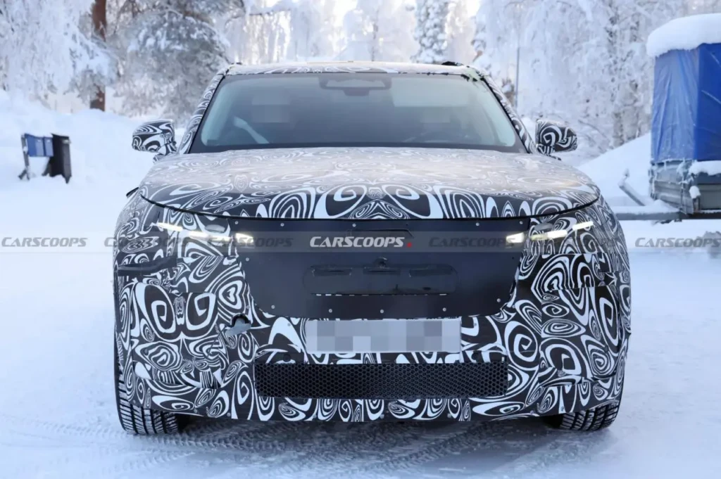 Фронтальний вигляд замаскованого прототипу кросовера на зимових тестах: авто в камуфляжі, снігова дорога, увімкнені фари.