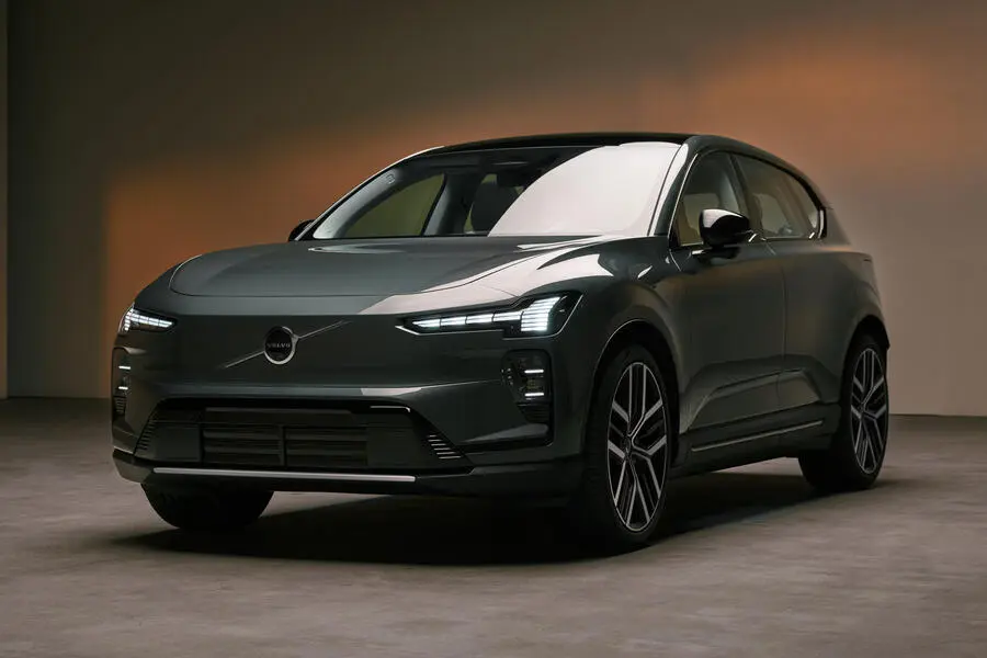 Volvo: тёмный электрический кроссовер, ракурс спереди сбоку, узкие LED-фары, студийный фон