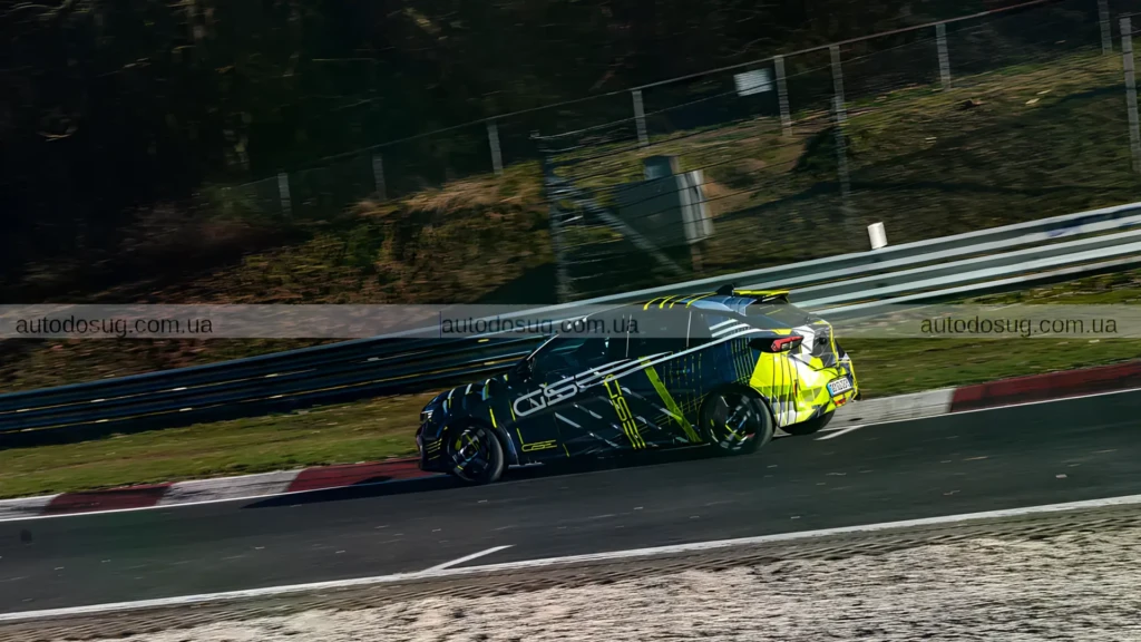 Камуфлированный Opel Corsa GSE на гоночной трассе, вид спереди сбоку