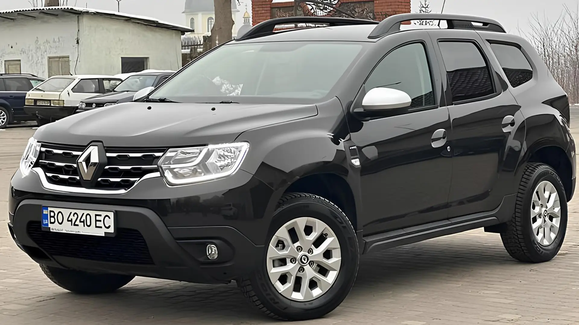 Чорний Renault Duster на парковці, вид спереду збоку