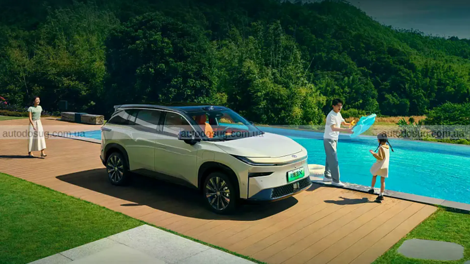 Білий сімейний електрокар BYD біля басейну поруч із родиною