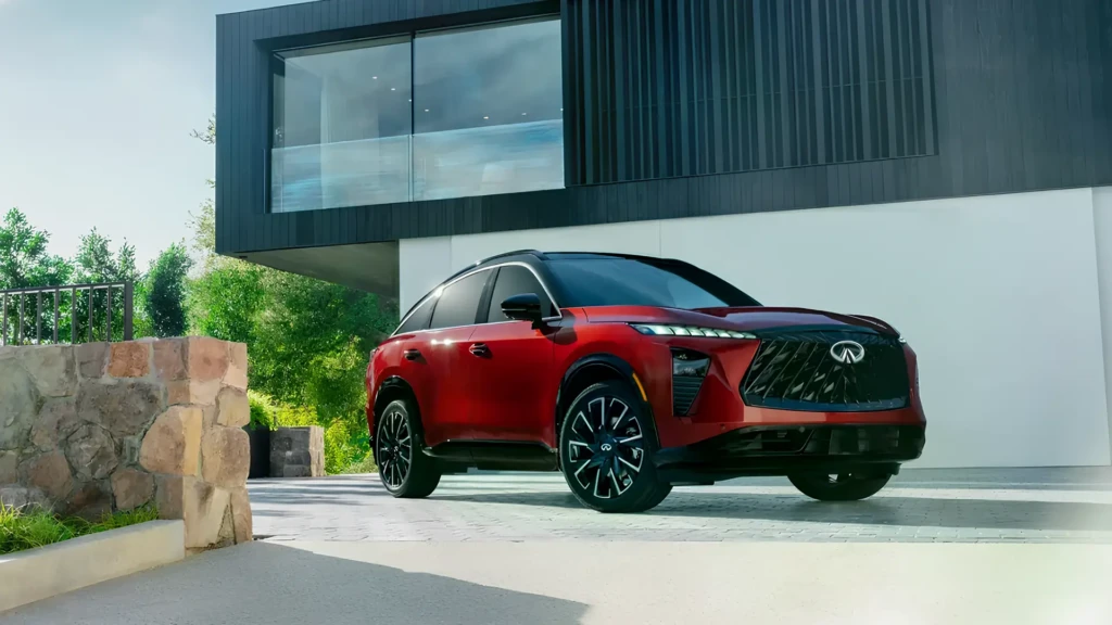 Infiniti QX65 червоного кольору біля сучасного будинку, вид спереду збоку