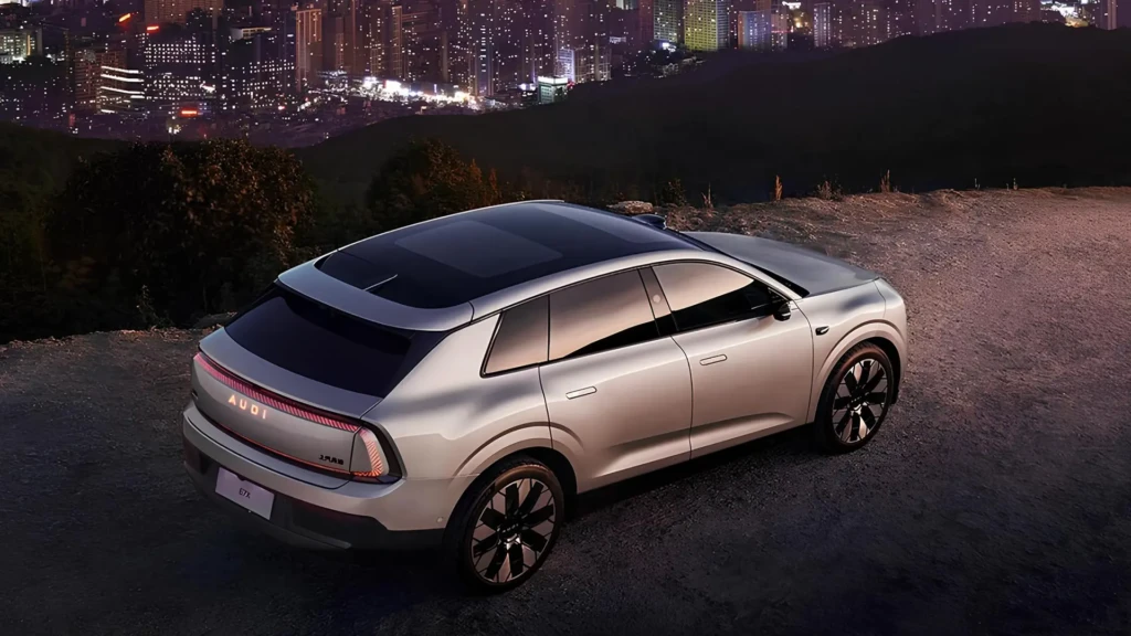 AUDI E7X сріблястого кольору, вид ззаду збоку на тлі нічного міста