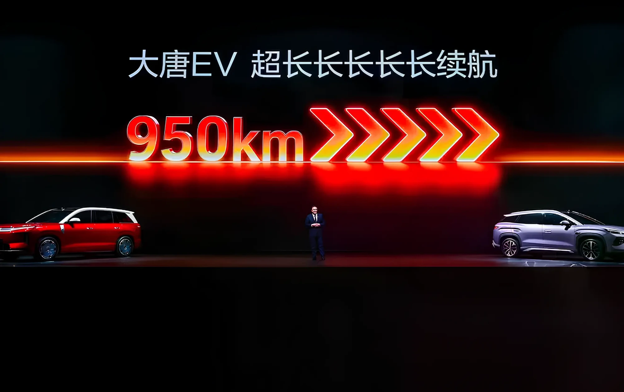 Слайд презентації про електромобіль: напис 950 км запасу ходу та китайський текст, по боках два авто на сцені