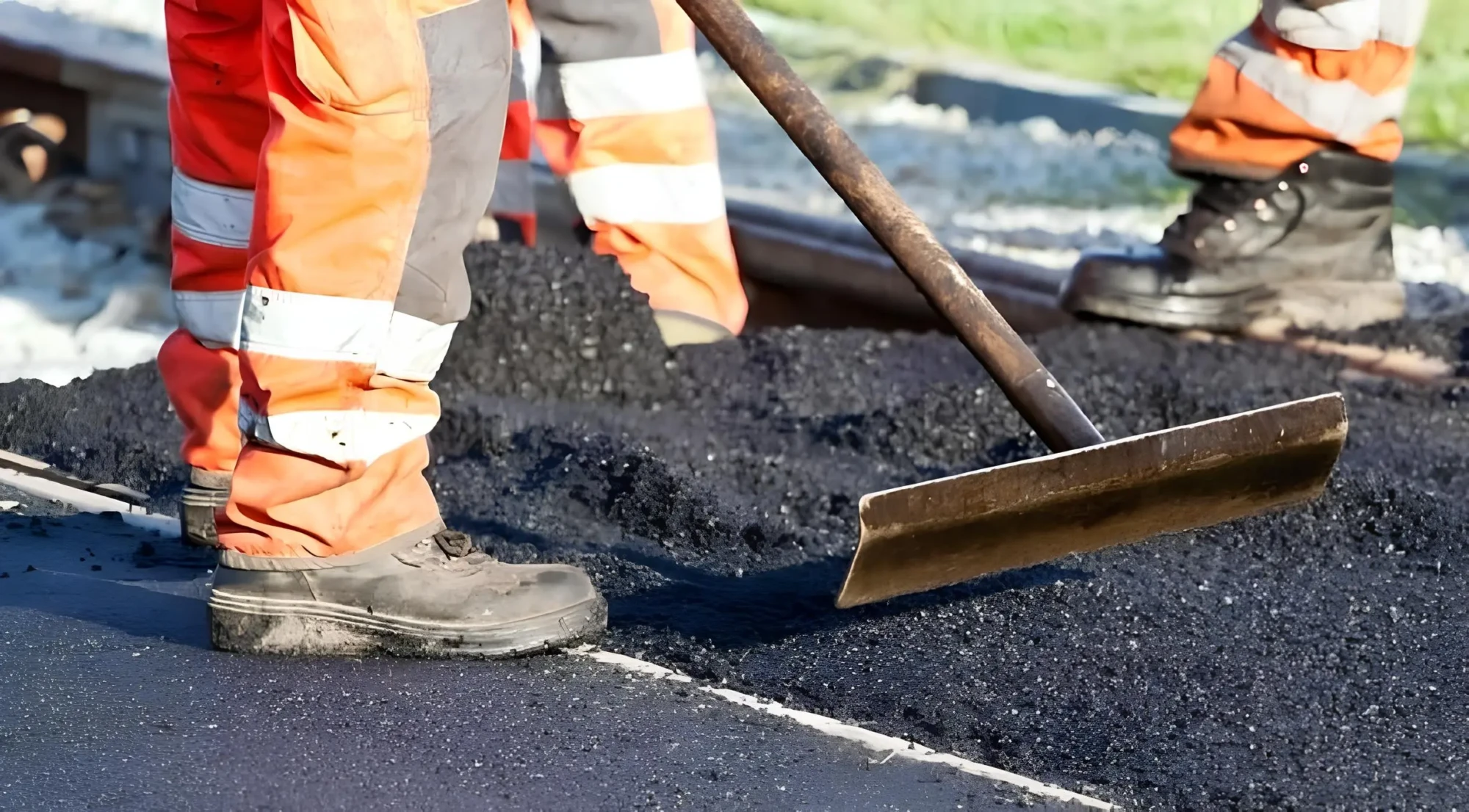 Працівники дорожньої служби укладають гарячий асфальт під час ремонту дороги