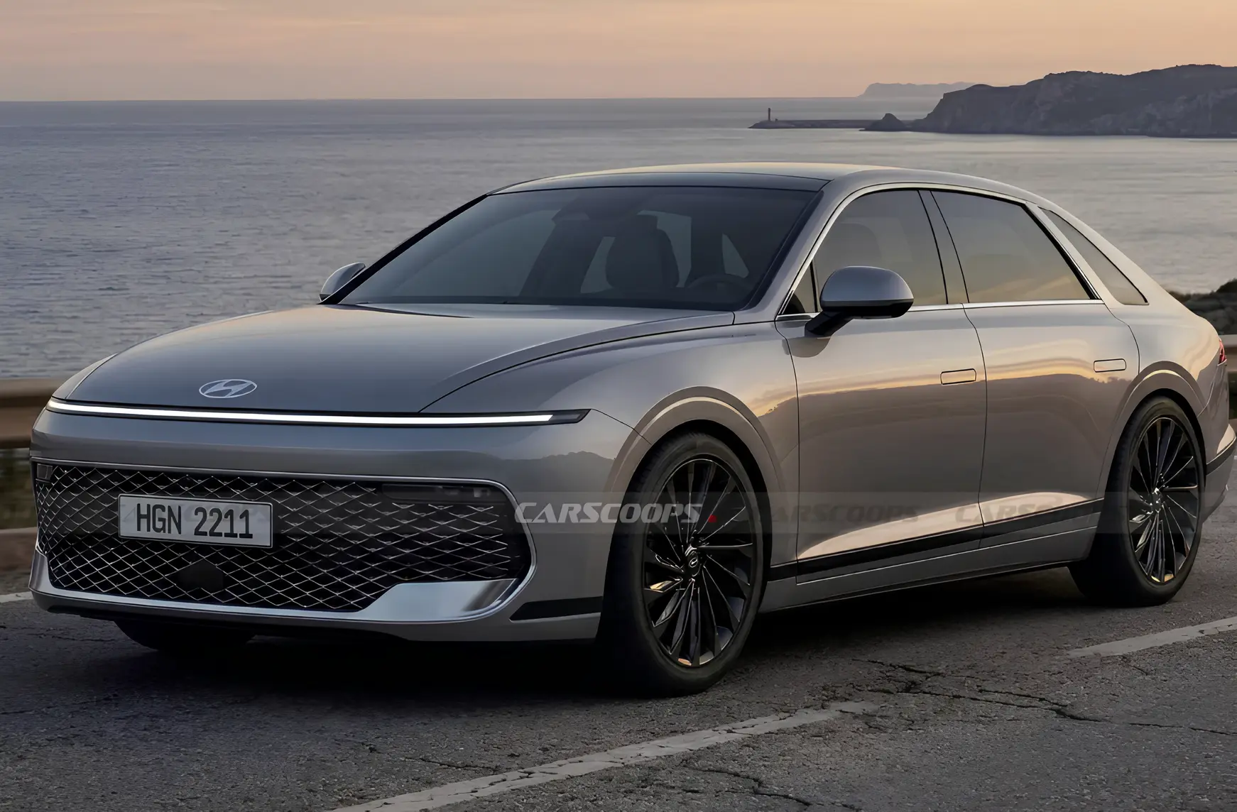 Сірий седан Hyundai Grandeur на узбережній дорозі на тлі моря; вид спереду збоку, вузька світлодіодна смуга фар і велика решітка