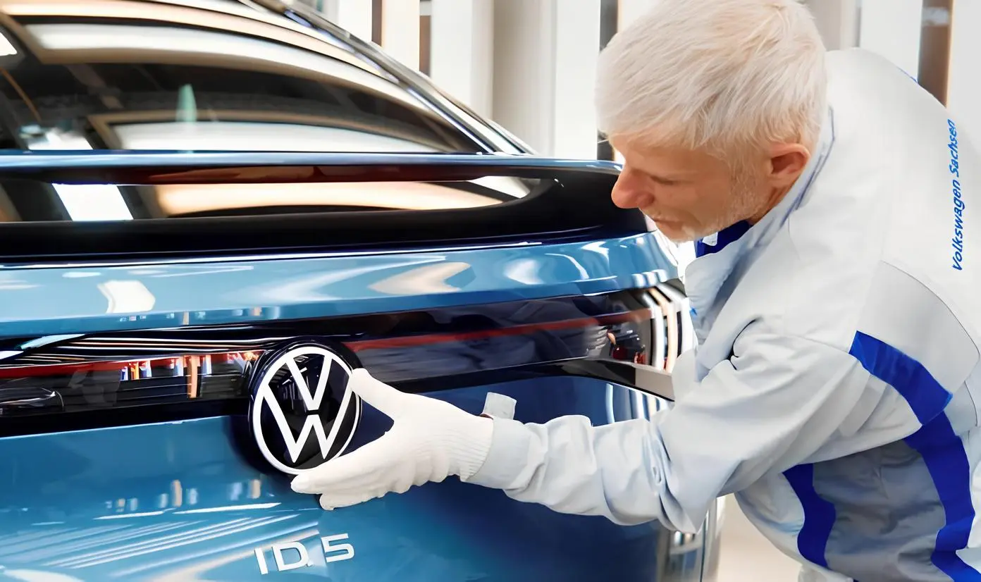 Volkswagen нові моделі 2026: працівник встановлює емблему VW на новий електромобіль