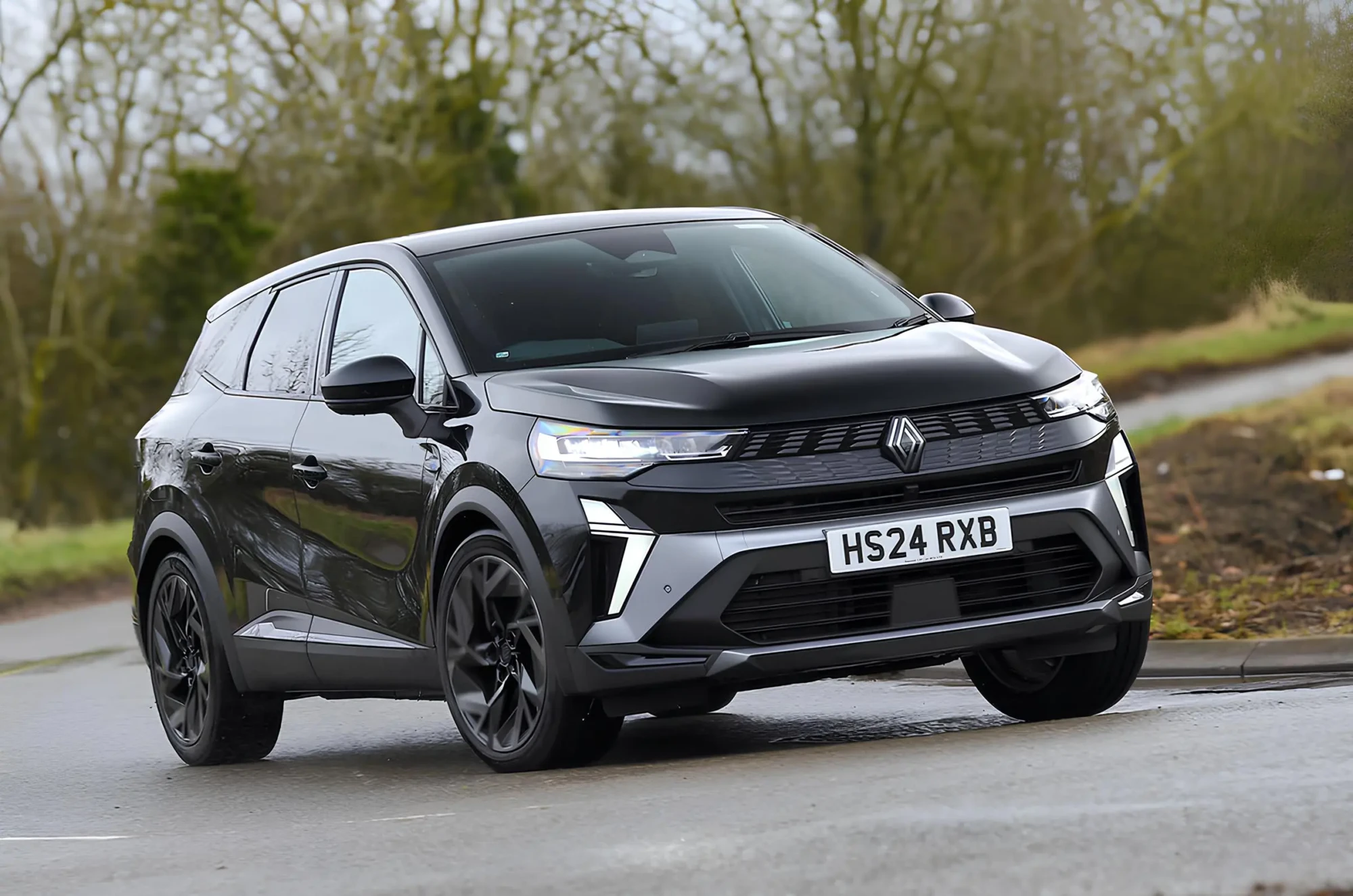 Чорний кросовер Renault у русі на мокрій дорозі, вигляд спереду збоку, світлодіодна оптика