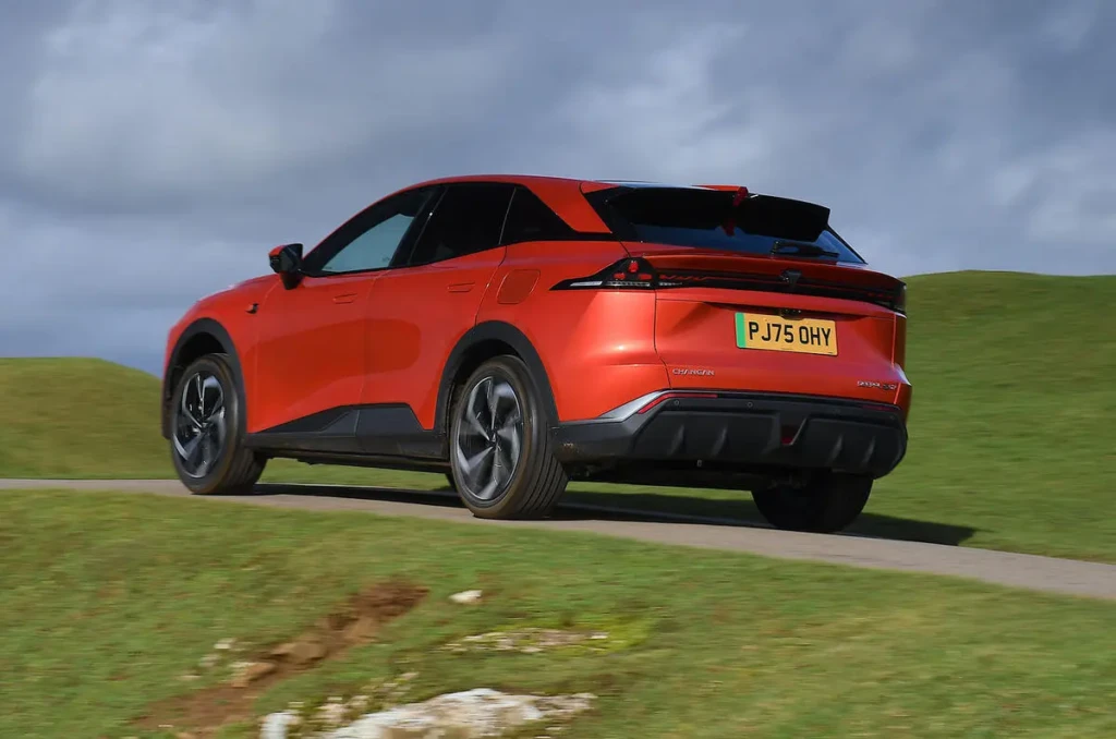 Червоний електричний кросовер Deepal S07 у русі, вигляд ззаду збоку, задня LED-оптика та спойлер