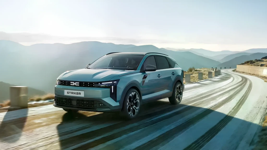 Dacia Striker на гірській дорозі: бірюзовий кросовер їде серпантином на тлі гірських хребтів