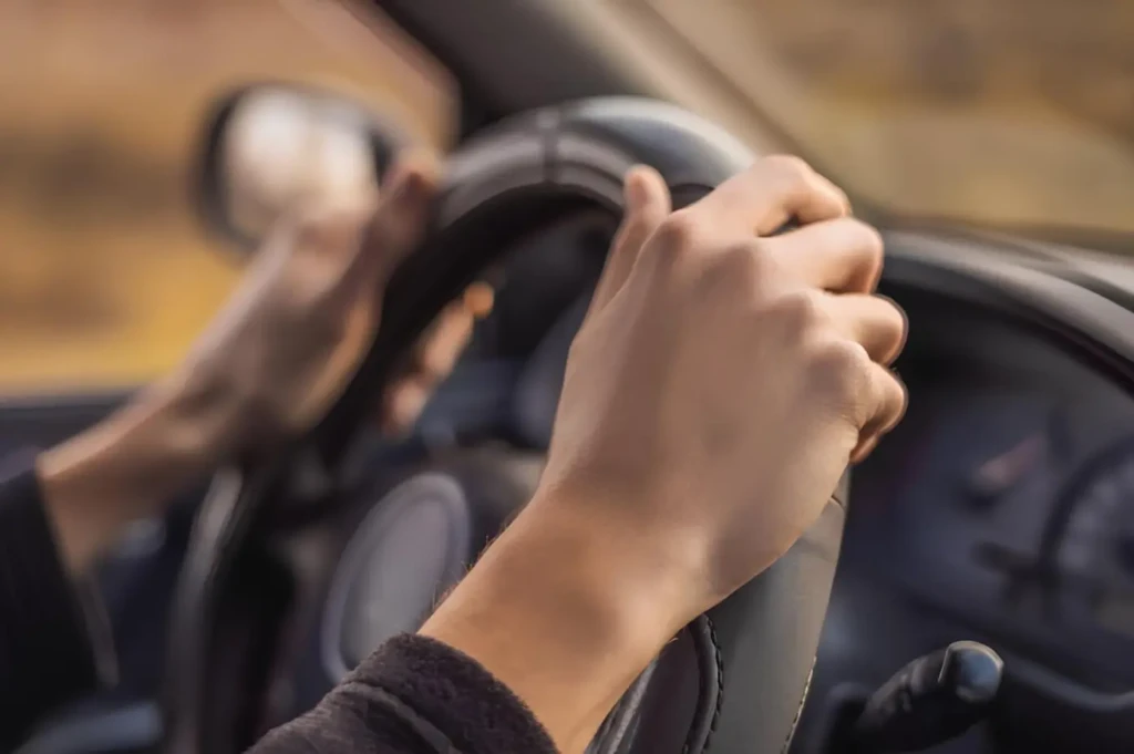 В Україні можуть змінити правила для водіїв 65+: руки водія за кермом автомобіля