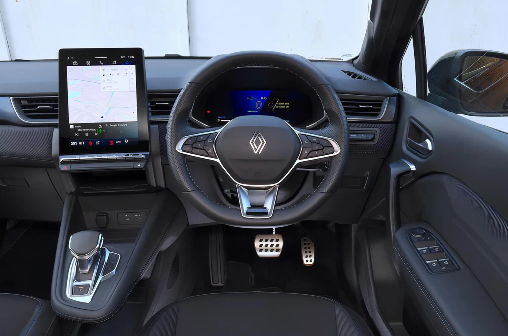 Салон Renault з місця водія: кермо з логотипом, цифрова панель приладів і вертикальний мультимедійний екран з навігацією