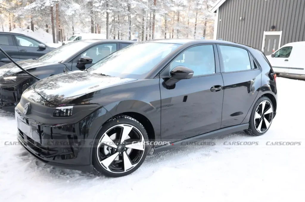 Volkswagen ID. Polo: черный электрический хэтчбек на снегу, вид спереди сбоку, с крупными двухцветными дисками