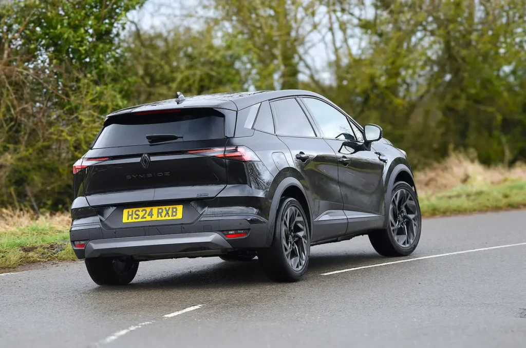 Черный кроссовер Renault в движении по мокрой дороге, вид спереди сбоку, светодиодная оптика