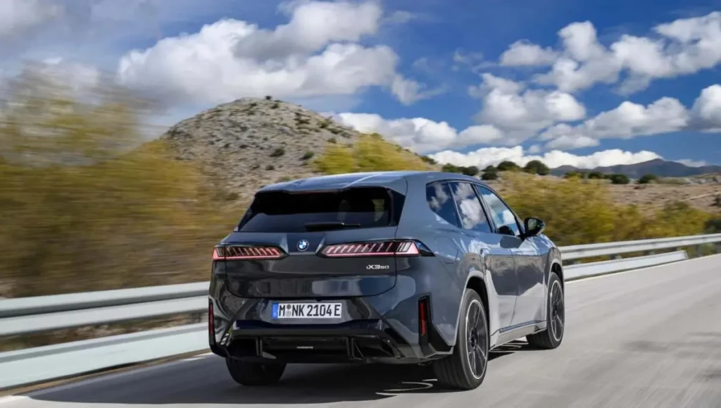 BMW iX3 Neue Klasse: електричний кросовер у задньому ракурсі під час руху дорогою