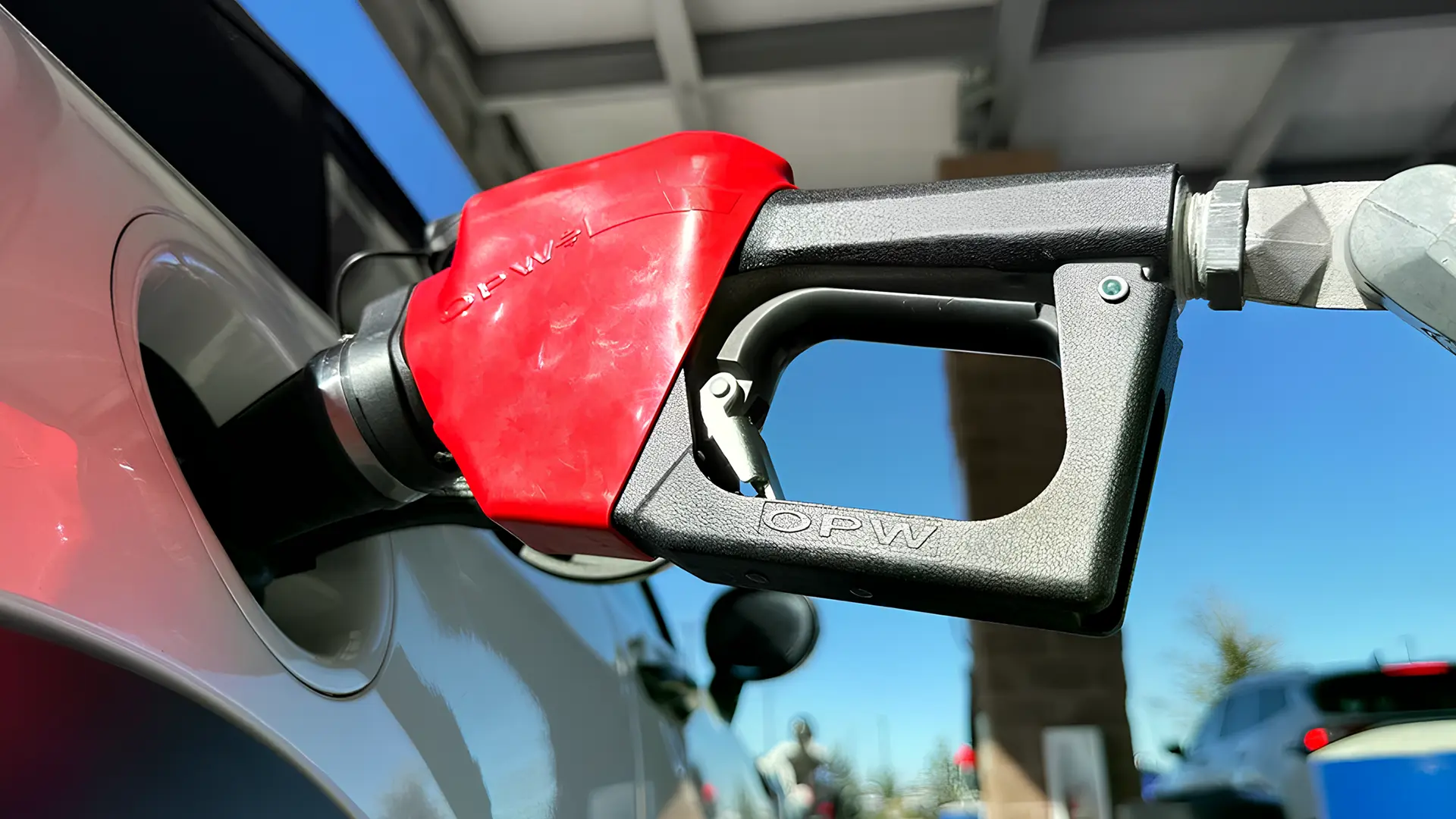 Заправний пістолет вставлений у паливний бак автомобіля на автозаправній станції