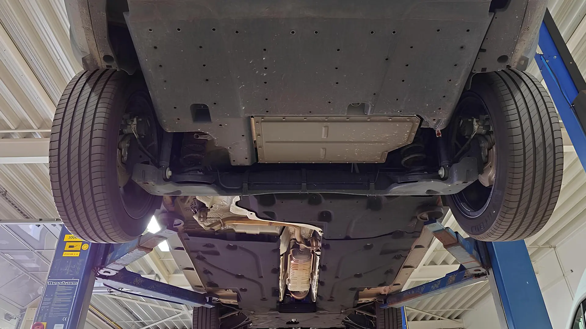 Нижня частина Dacia Bigster на підйомнику в сервісному центрі