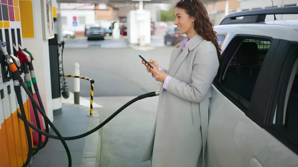 Жінка заправляє автомобіль на АЗС як ілюстрація до теми цін на пальне в Україні