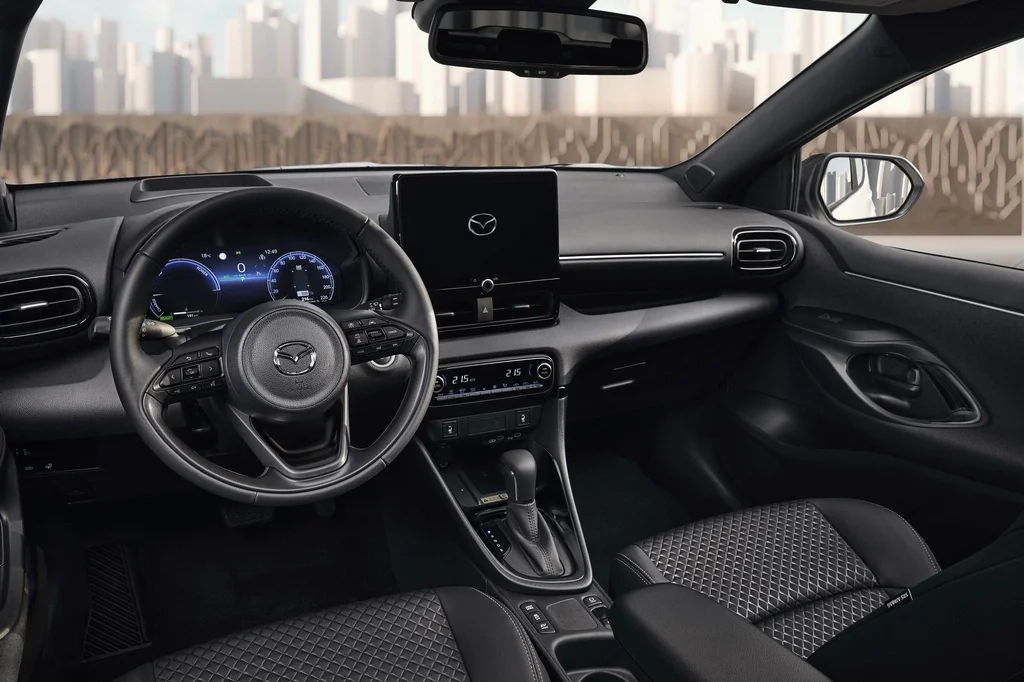 Білий Mazda2 Hybrid 2026 у русі заміською дорогою