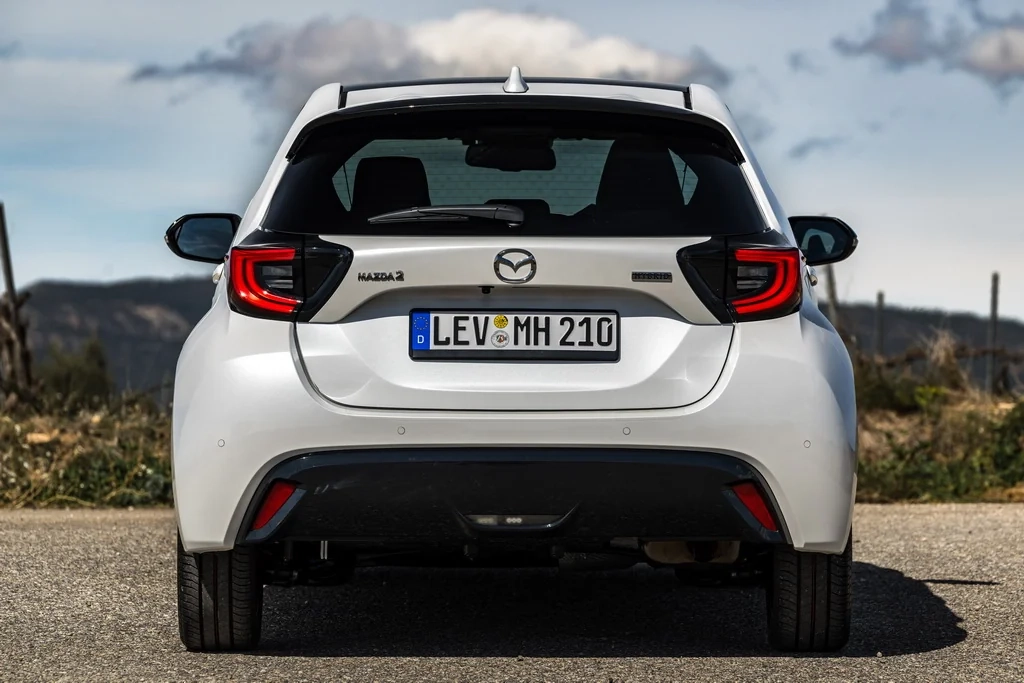 Білий Mazda2 Hybrid 2026 у русі заміською дорогою