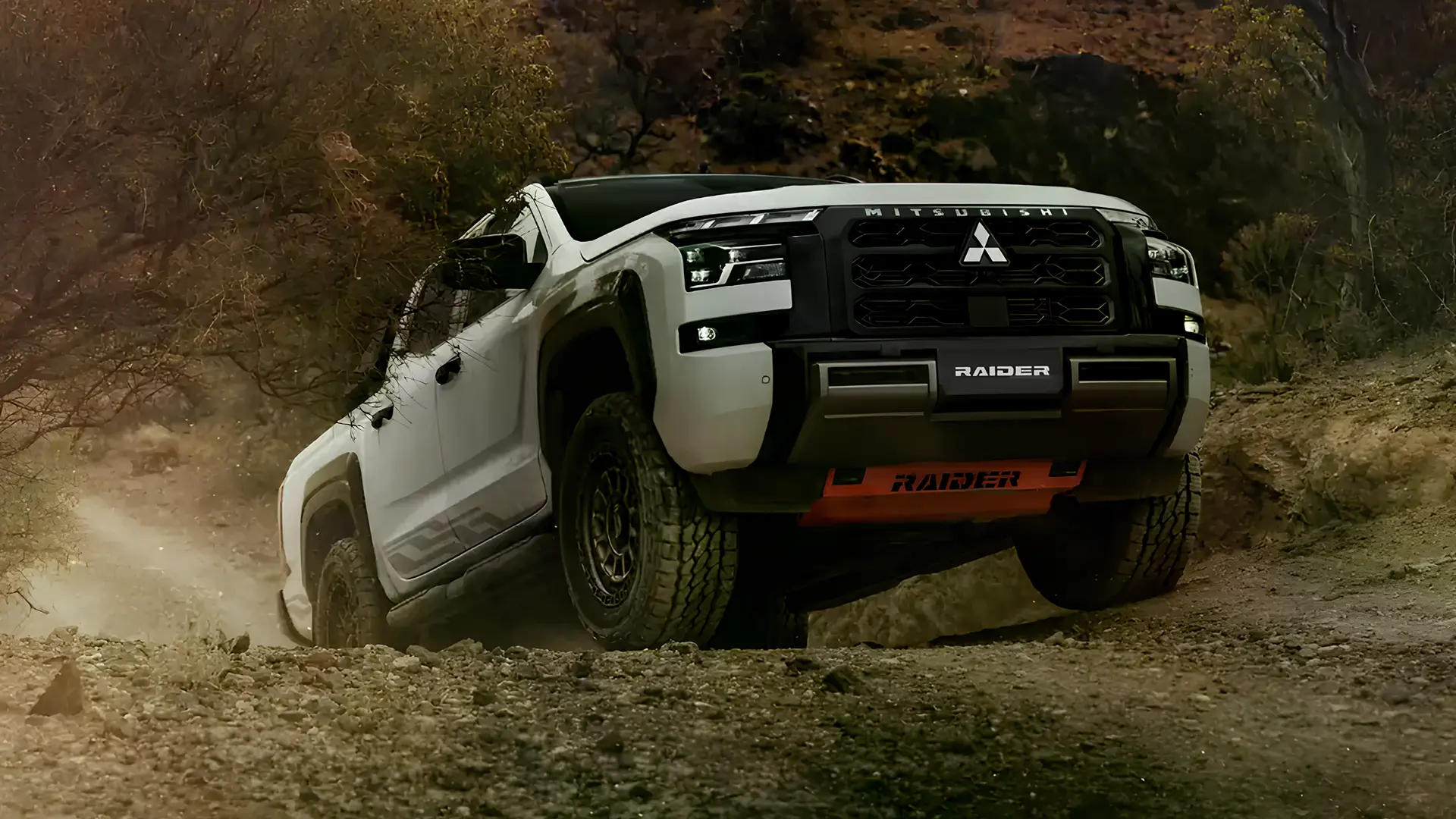 Пікап Mitsubishi Triton Raider долає кам’янисту позашляхову ділянку, вид спереду