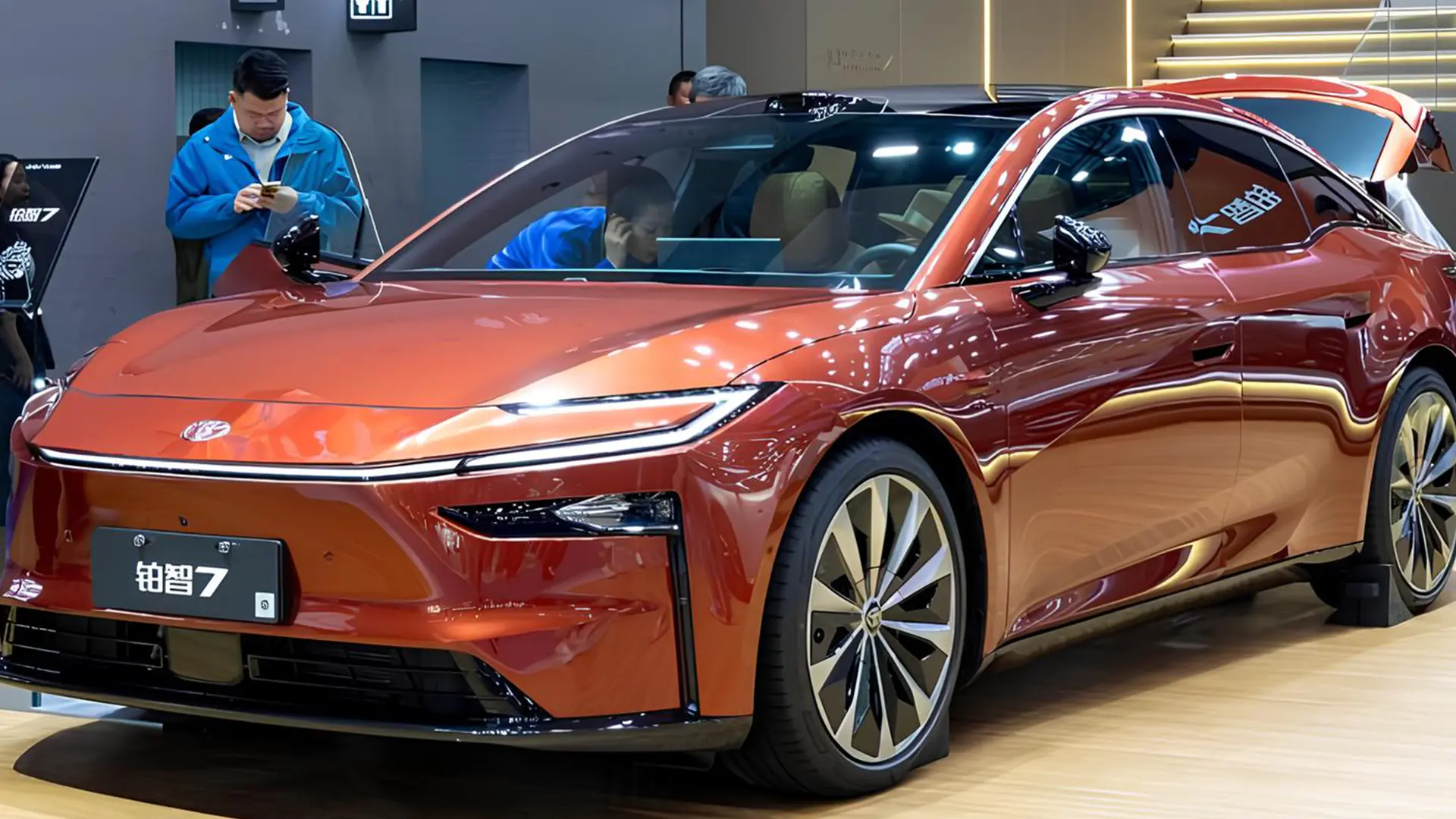 Електричний седан Toyota bZ7 помаранчевого кольору на автомобільній виставці