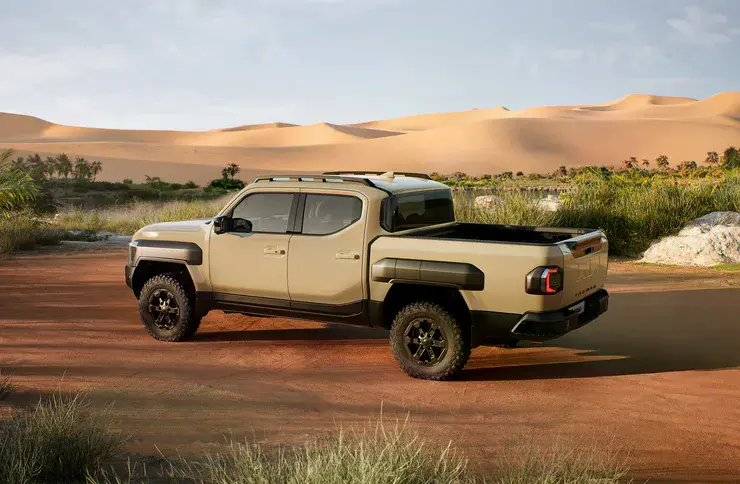 Пікап Kia Tasman на тлі пустельного пейзажу, вигляд збоку ззаду