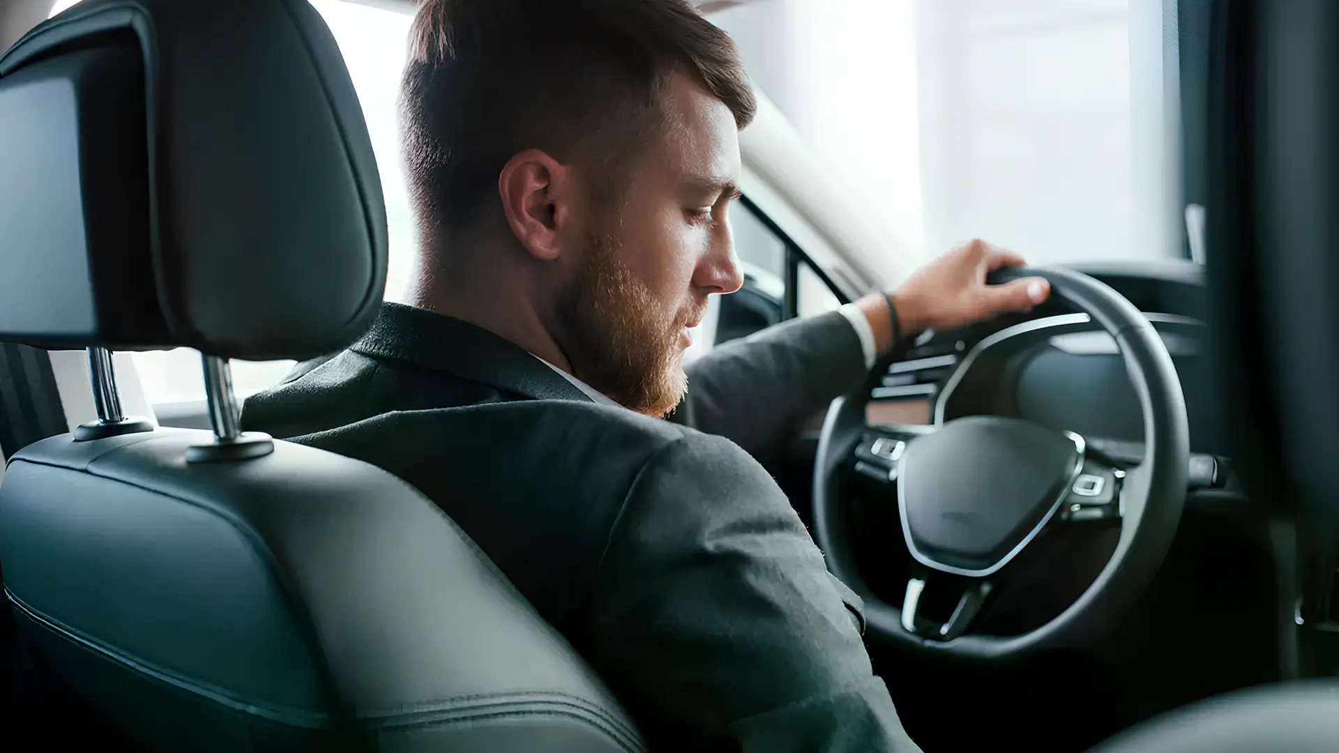 Водій за кермом автомобіля під час поїздки містом