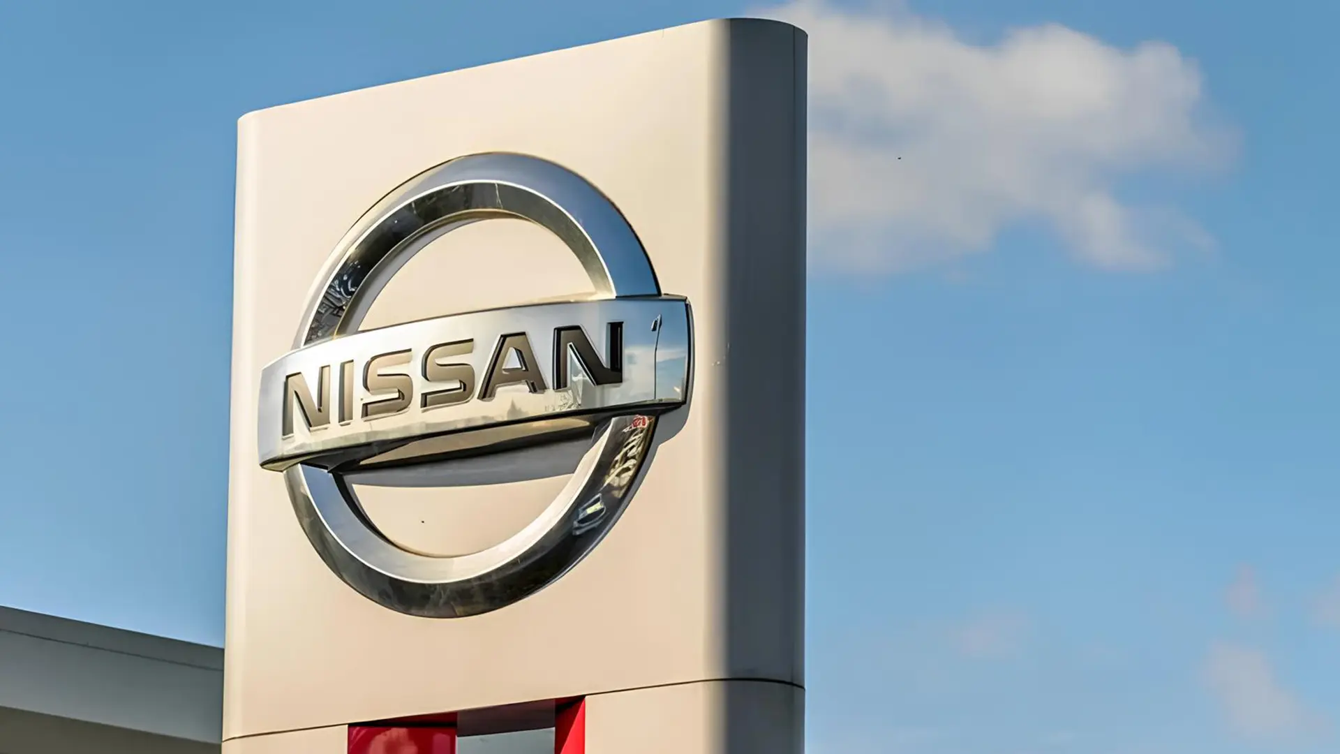 Логотип Nissan на фірмовій вивісці на тлі блакитного неба