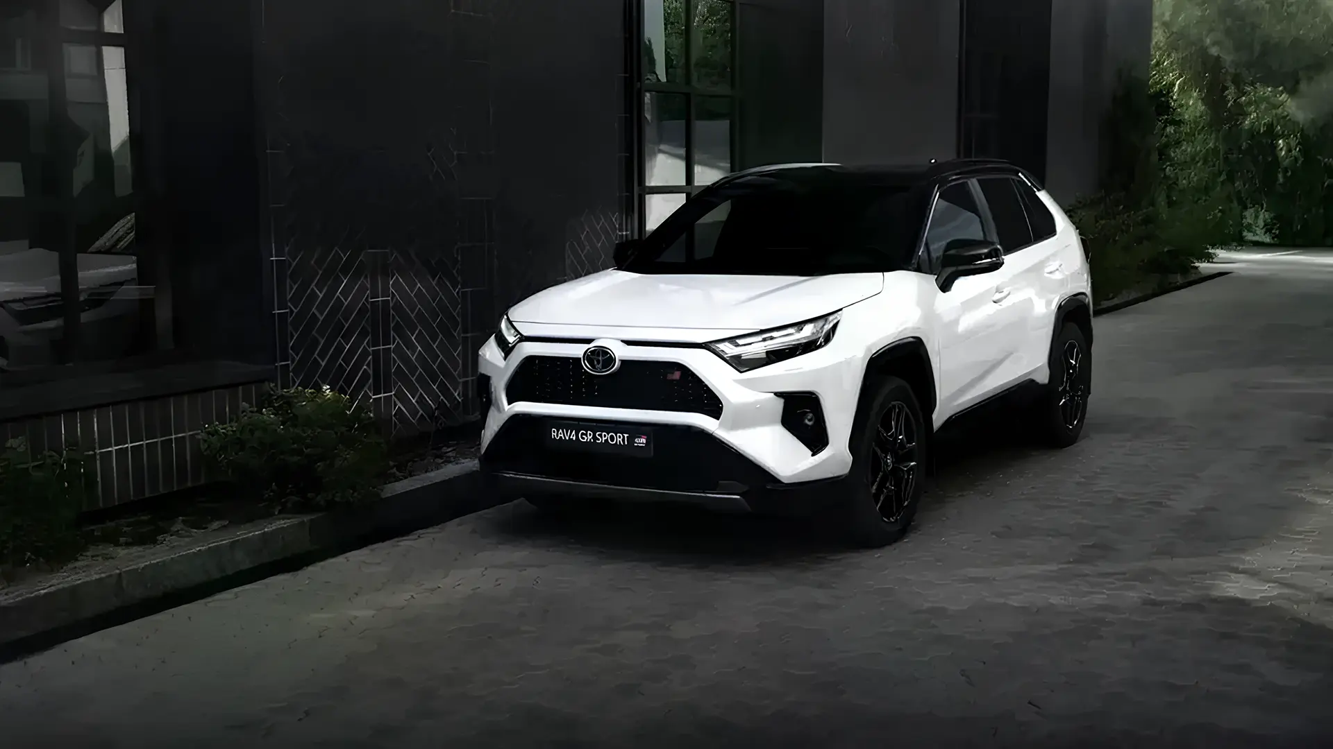 Новий Toyota RAV4 білого кольору на міській вулиці біля сучасної будівлі