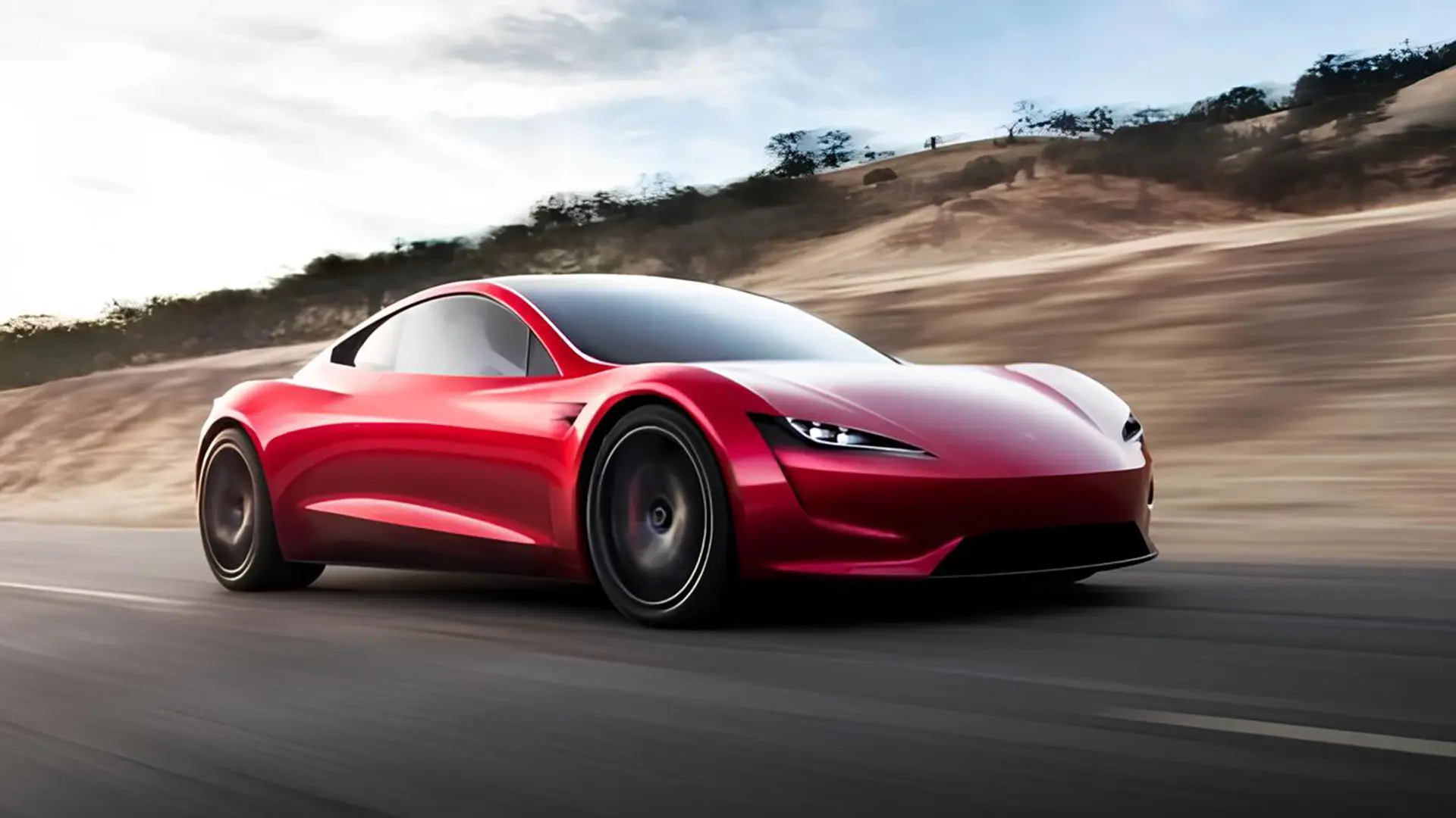 Червоний електричний спорткар Tesla Roadster у русі на дорозі
