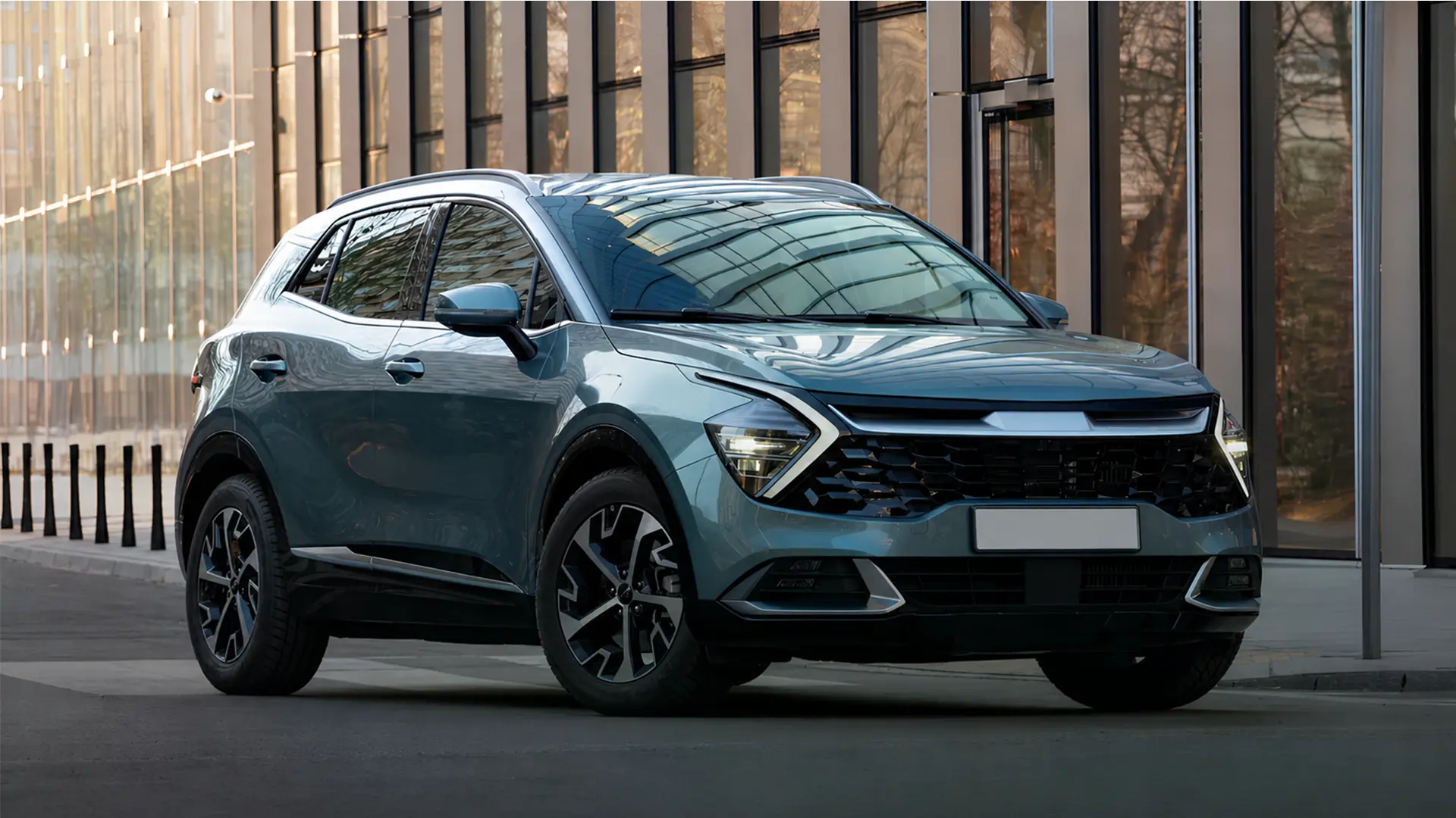 Kia Sportage 2026 блакитного кольору біля сучасної будівлі